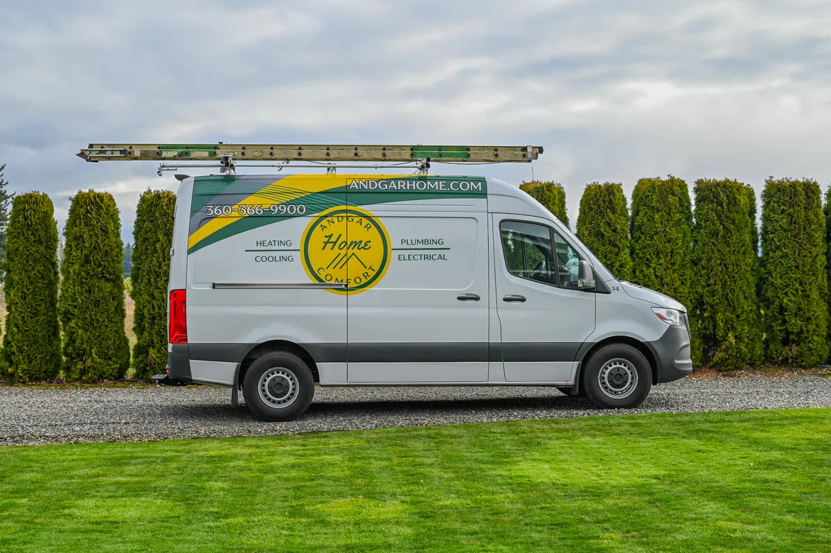 Andgar Home Comfort service van with ladder parked by a lawn