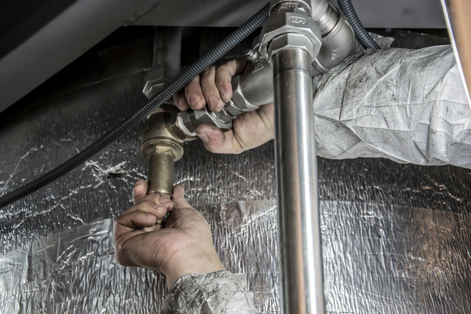 Plumbing pipes and fixtures beneath a sink